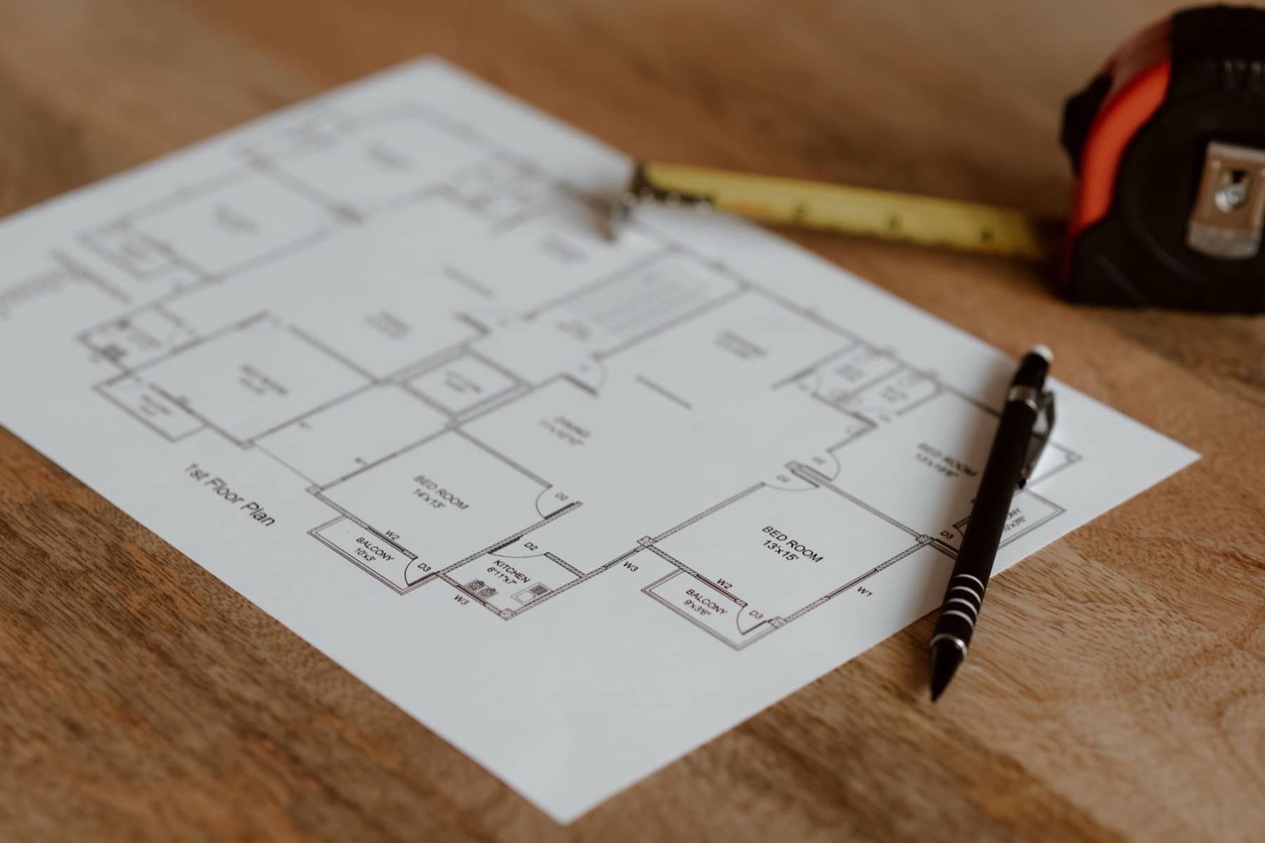 Printed house floor plan on a wooden table with a pencil and tape measure, Sioux Falls area
